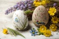 Painted Easter eggs with spring flowers on a white wooden table, Generative AI Royalty Free Stock Photo