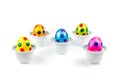 Painted easter eggs standing in porcelain egg cups on white Royalty Free Stock Photo