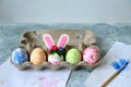 Painted eggs and one egg decorated with bunny ears, diy easter eggs concept Royalty Free Stock Photo