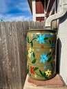 Painted Flowers on Green Rain Barrel by Wood Fence Royalty Free Stock Photo