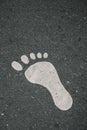 Painted Footprint On Asphalt . Vertical shot , close up