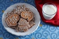 Painted gingerbread cookies on a plate and a glass of milk