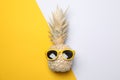 Painted gold pineapple with sunglasses on two tone background Royalty Free Stock Photo