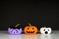 Painted Halloween pumpkins on a white shelf against a black background