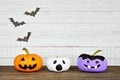 Painted Halloween pumpkins on a wood shelf against a rustic white wood background