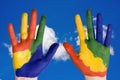 Painted hands on blue sky background. Royalty Free Stock Photo