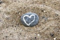 Painted heart on stone lying in sand Royalty Free Stock Photo