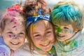 Painted kids face on colorful background holi, closeup. Festival of colors. Children draws paints. Royalty Free Stock Photo