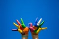 Painted kids hands on blue sky backgrobnd Royalty Free Stock Photo