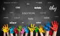 Painted kids hands in front of a blackboard with the word `hello ` in many languages