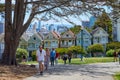 THE PAINTED LADIES, SAN FRANCISCO, CALIFORNIA, USA Ã¢â¬â JUNE 25, 2021: People walking across Alamo Square Park next to The Painted Royalty Free Stock Photo