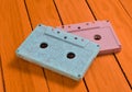 Painted in a pink blue pastel color audio cassette on an orange wooden background. Royalty Free Stock Photo