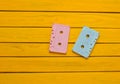 Painted in a pink blue pastel color audio cassette on a yellow wooden background. Retro audio technology Royalty Free Stock Photo