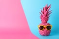 Painted pink pineapple with sunglasses on two tone background Royalty Free Stock Photo