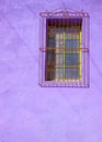 Painted Purple Stucco Wall with Barred Window Royalty Free Stock Photo