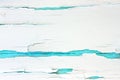 Painted rough wooden background, old wall with cracked paint white on turquoise backdrop.