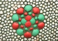 Painted seashells on a wall forming a red and green flower Royalty Free Stock Photo