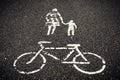 Painted sign on asphalt, bicycle woman with child