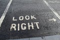 Painted sign on roadway,advising one to look right before crossing