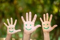 Painted smiley face on the palms against green background