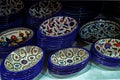 Painted souvenir plates on the counter in the store of Jerusalem, Israel. National ornament on a plate with blue edging