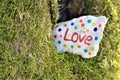 A painted stone with word `love` left in the tree