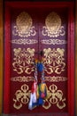 Painted with traditional buddhist symbols red door with laced hadags sacred scarves as handles in Tovkhon Monastery, Mongolia Royalty Free Stock Photo