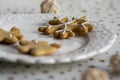 Painted traditional Christmas gingerbreads arranged on white plate, tablecloth with golden stars, snowflake and reindeer shapes Royalty Free Stock Photo