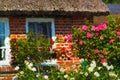 Painted traditional reed roof covered house with cottage garden on island Ruegen Royalty Free Stock Photo