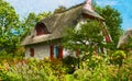 Painted traditional reed roof covered house with cottage garden on island Ruegen Royalty Free Stock Photo