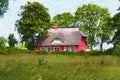 Painted traditional reed roof covered house with cottage garden on island Ruegen