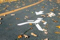 Painted white pedestrian symbol with arrow on asphalt road at city street or park on autumn day. Dedicated walkpath lane Royalty Free Stock Photo
