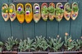 Painted Wooden Dutch Clog Shoes Decorating the Side of a Building with budding Tulips