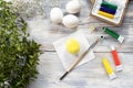 Painted yellow easter egg with paintbrush and paints on wooden table Royalty Free Stock Photo