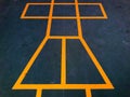 Painted yellow lines contrast against the dark asphalt and form the classic school playground game of Hopscotch Royalty Free Stock Photo