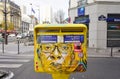 Painted yellow mailbox covered with street art by French graffiti muralist C215 in Paris