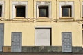 Painted in yellow wall of building with boarded up windows and doors Royalty Free Stock Photo