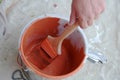 Painter Applies Orange Paint to Brush from Pail