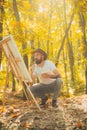 Painter artist forest. Art concept. Painting in nature. Start new picture. Painter with easel and canvas. Bearded man Royalty Free Stock Photo