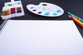 Painter artist work space paper pencil paintbrush paints at angle dark background