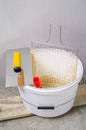 Painter bucket with net, trowel and roller in front of gypsum wa Royalty Free Stock Photo