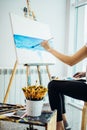 Painter, european girl drawing sea-scape on canvas in her workshop. Concept of fine-art classes Royalty Free Stock Photo