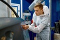 Painter examining car body paint check process Royalty Free Stock Photo