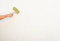 Painter hand is painting a house wall with roller. Royalty Free Stock Photo