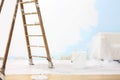 Painter house concept, wooden ladder, bucket, and white wall Royalty Free Stock Photo