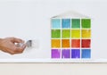 Painter man hand with paint brush painting colored house model o Royalty Free Stock Photo