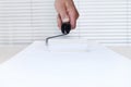 Painter man hand with paint roller, painting on white board back Royalty Free Stock Photo