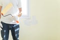 Painter man hands with gloves holds painting roller for renovation interior wall house. Worker using paint roller for decoration, Royalty Free Stock Photo