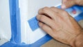 Painter Man Using Masking Blue Tape to Secure Baseboard, Moulding Royalty Free Stock Photo