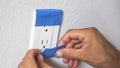 Painter Man Using Masking Blue Tape to Secure Electric Outlet Royalty Free Stock Photo